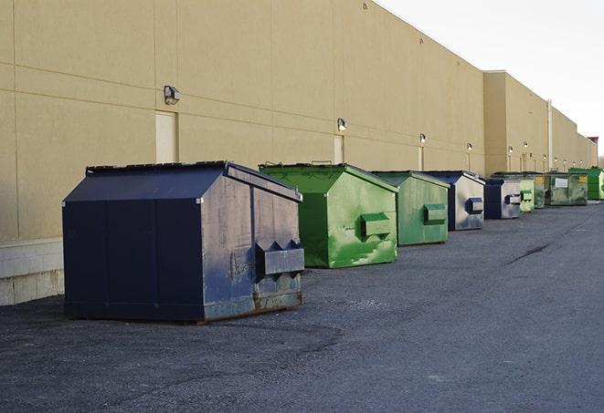 a waste management truck unloading into a construction dumpster in Edgefield